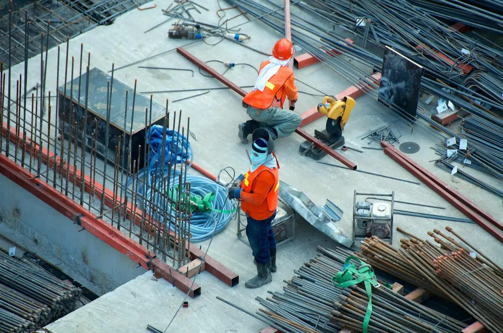 Cantiere strutturale con armature in acciaio e tecnici al lavoro
